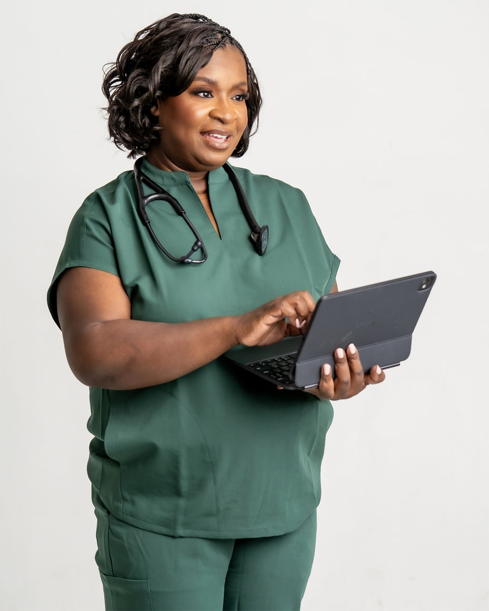 Dr. Eva Berry in clinical scrubs using a tablet.